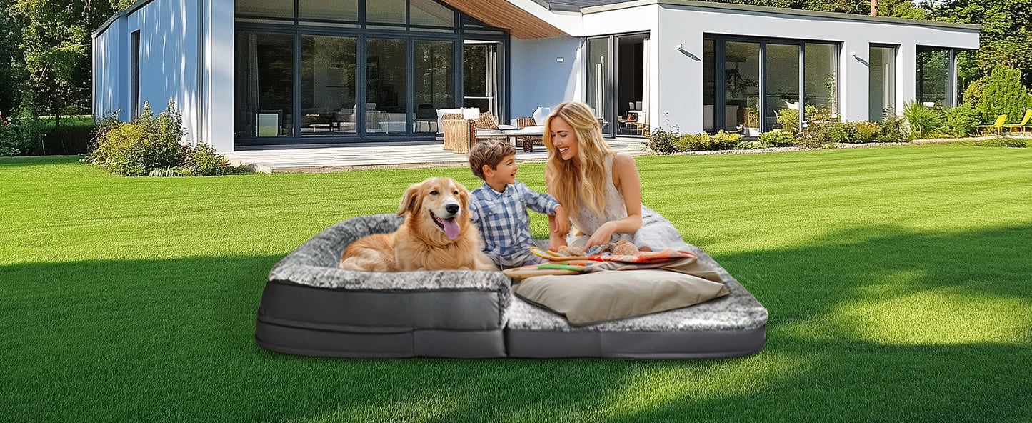 Moment de détente partagé sur un lit géant pour chien et humain, posé dans le jardin.