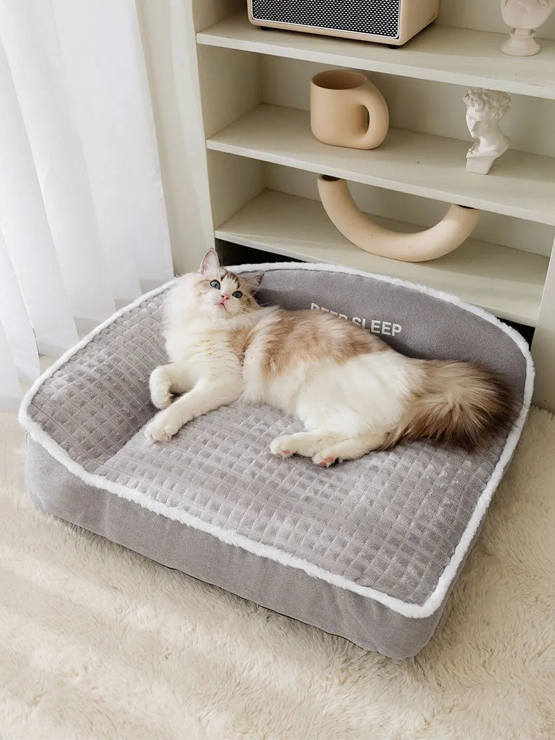 Petit chien blanc endormi confortablement sur un coussin moelleux gris doux et chaud