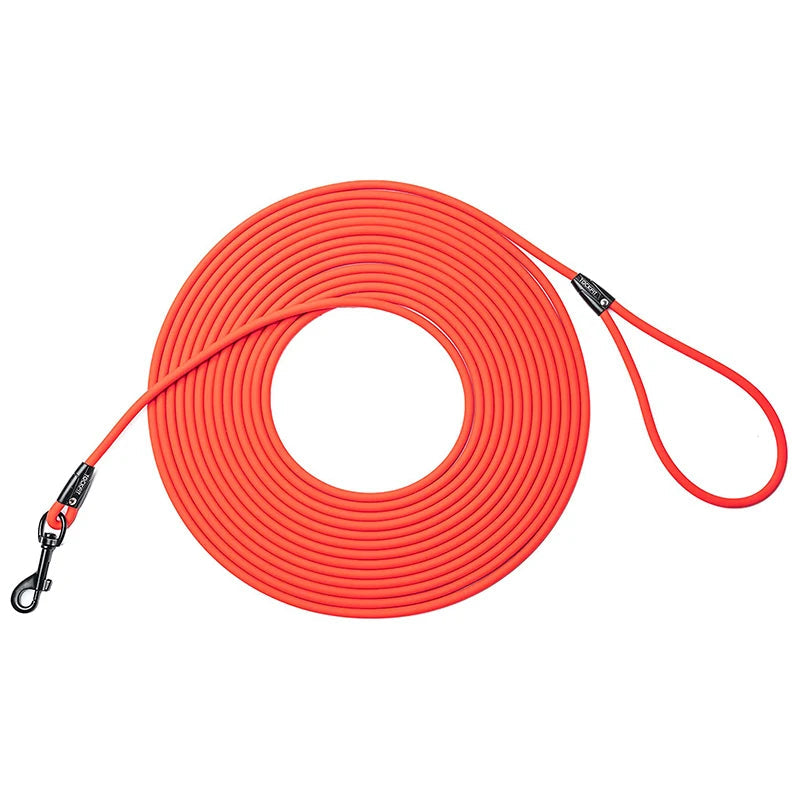 Longe pour chien en PVC et en nylon enroulé sur une table pour la démonstration. Taille disponible, 1m50, 3 M, 6 M et 9 M.