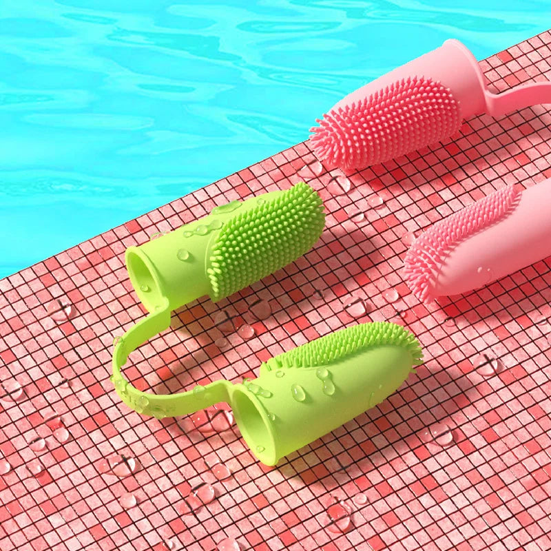 Deux brosses à dents souples exposées sur un tapis. Silicone non toxique, adapté aux chiens et chats.