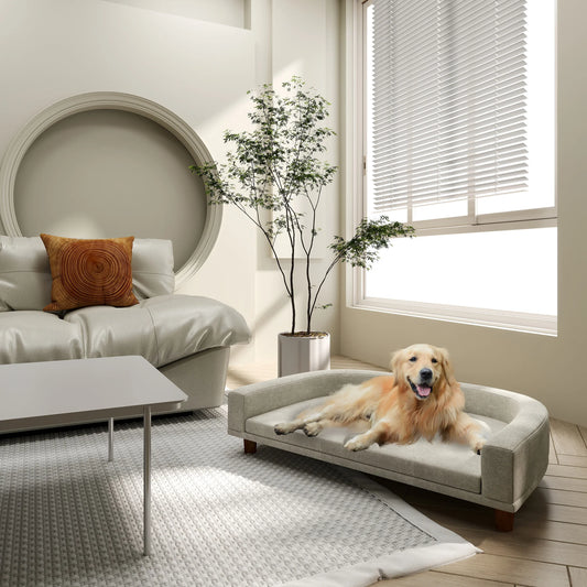 Canapé pour chien installé dans un salon. Parfaitement intégré à la déco, avec deux chiens couchés.