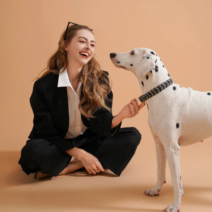 Jeune femme assise au sol avec son chien dalmatien et collier stylé