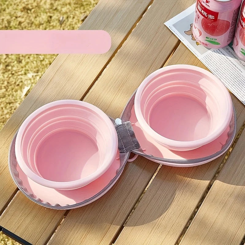 Gamelle pliable double pour chien en rose et blanc, ouverte pour recevoir eau et nourriture.