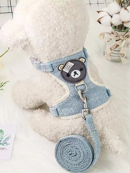 petit chien blanc portant le harnais Winnie l’Ourson bleu avec laisse assortie