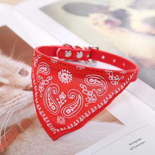 Collier foulard rouge plié en triangle sur une table blanche