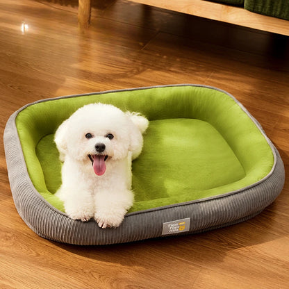 Petit chien blanc assis dans un coussin pour chien lavable vert et gris, confortable et déhoussable.