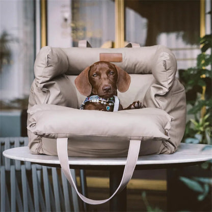 Petit chien couché dans un panier de voiture beige portable, utilisé comme lit d’appoint en voyage.