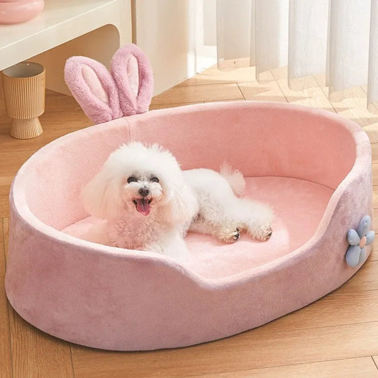 petit chien blanc couché dans un panier pour petit chien rose avec oreilles de lapin décoratives