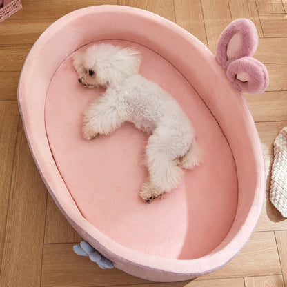 vue de dessus d’un petit chien couché dans un panier pour petit chien rose avec rebords sécurisants