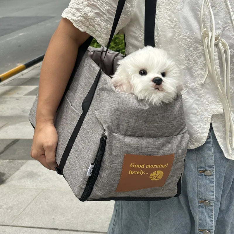 femme portant un sac de transport pour petit chien en tissu gris avec un chiot blanc