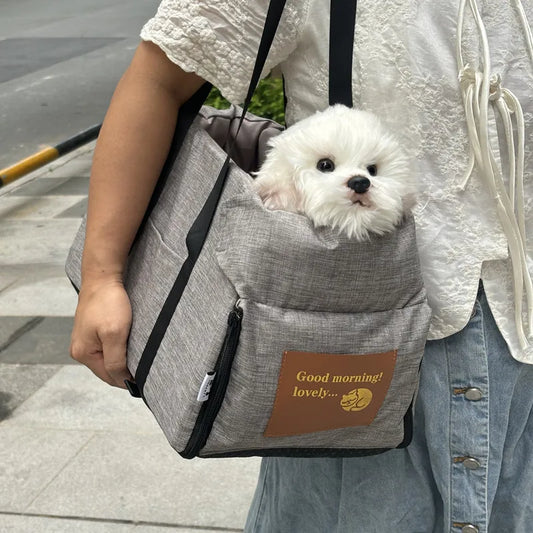 femme portant un sac de transport pour petit chien en tissu gris avec un chiot blanc