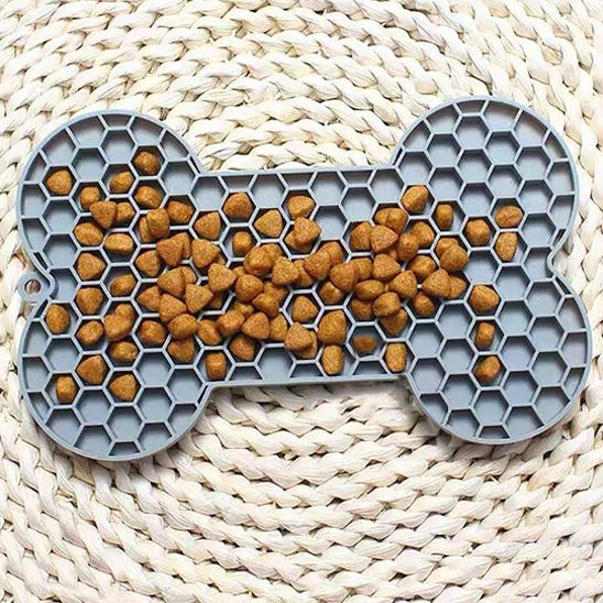 chien couché dans le salon utilisant un tapis de léchage grand chien gris